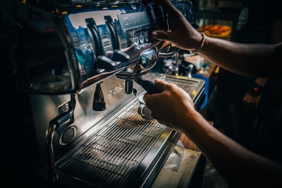 Hands at a professional espresso machine